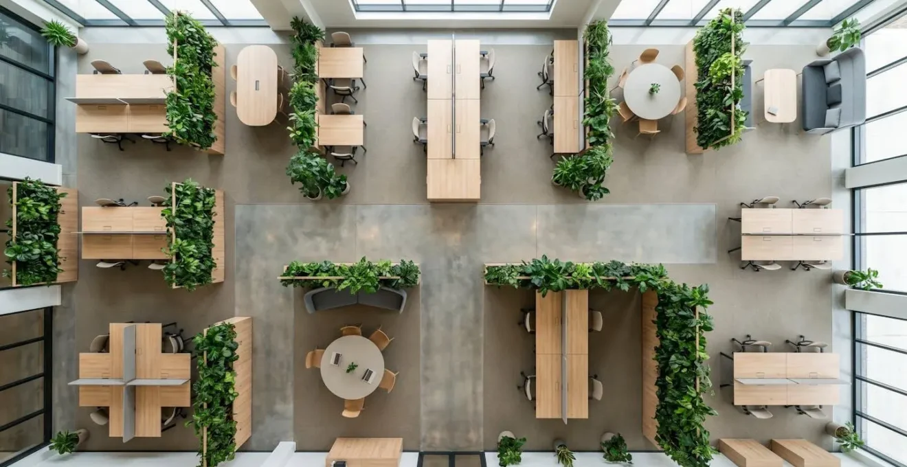 Vue aérienne d'un bureau moderne avec espaces de travail flexibles et zones de collaboration végétalisées