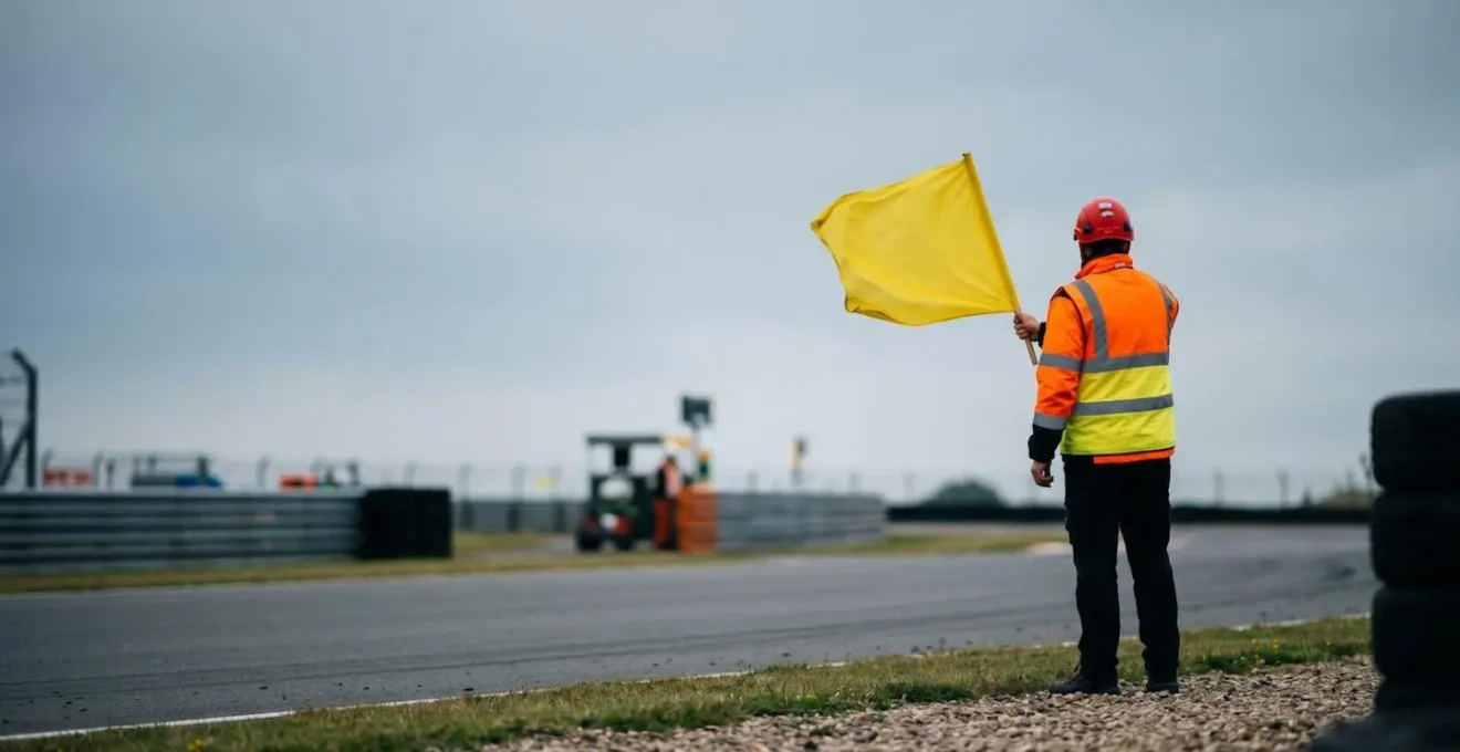 Commissaire de piste agitant un drapeau de signalisation sur circuit automobile