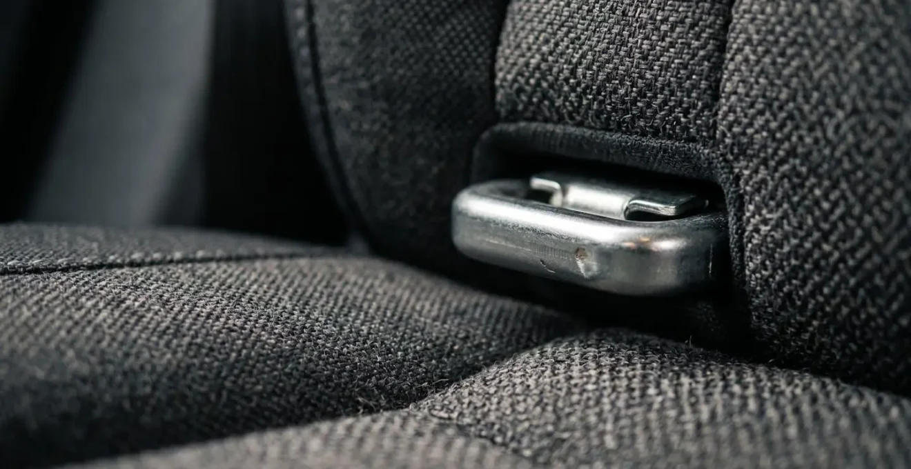Gros plan détaillé sur les ancrages métalliques Isofix entre l'assise et le dossier d'une banquette arrière